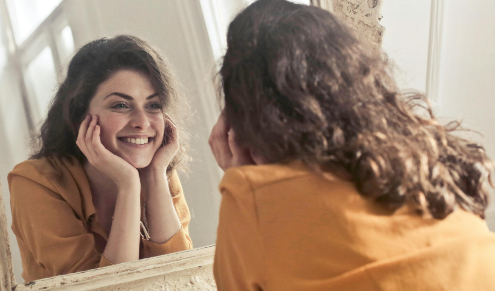 Woman admiring smile in mirror