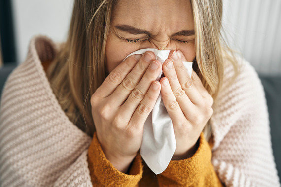 woman blowing nose during cold and flu season